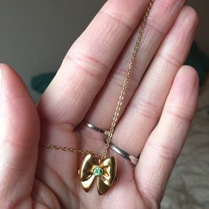 Gold bow necklace with August birthstone.